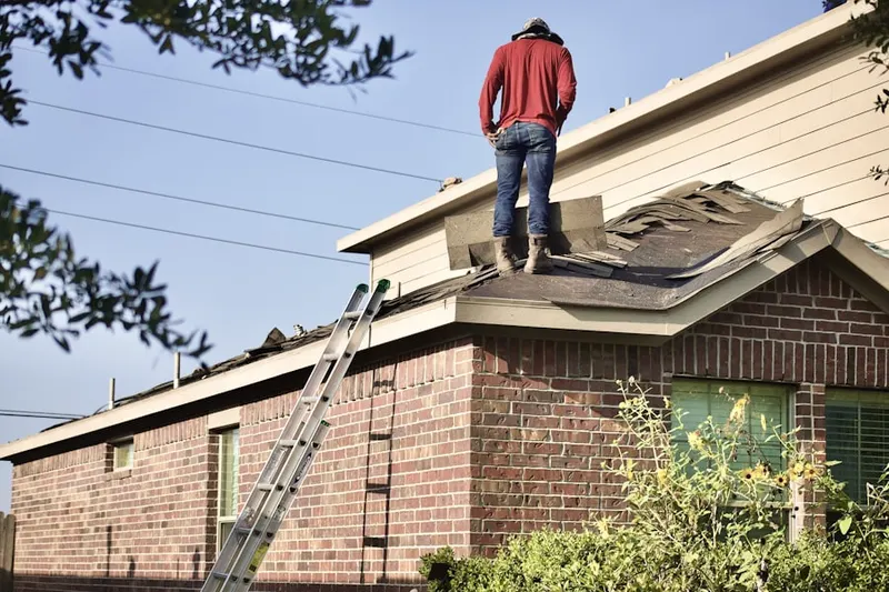 Professional roofer working on a residential roof in Robert Hutt Congregate Housing